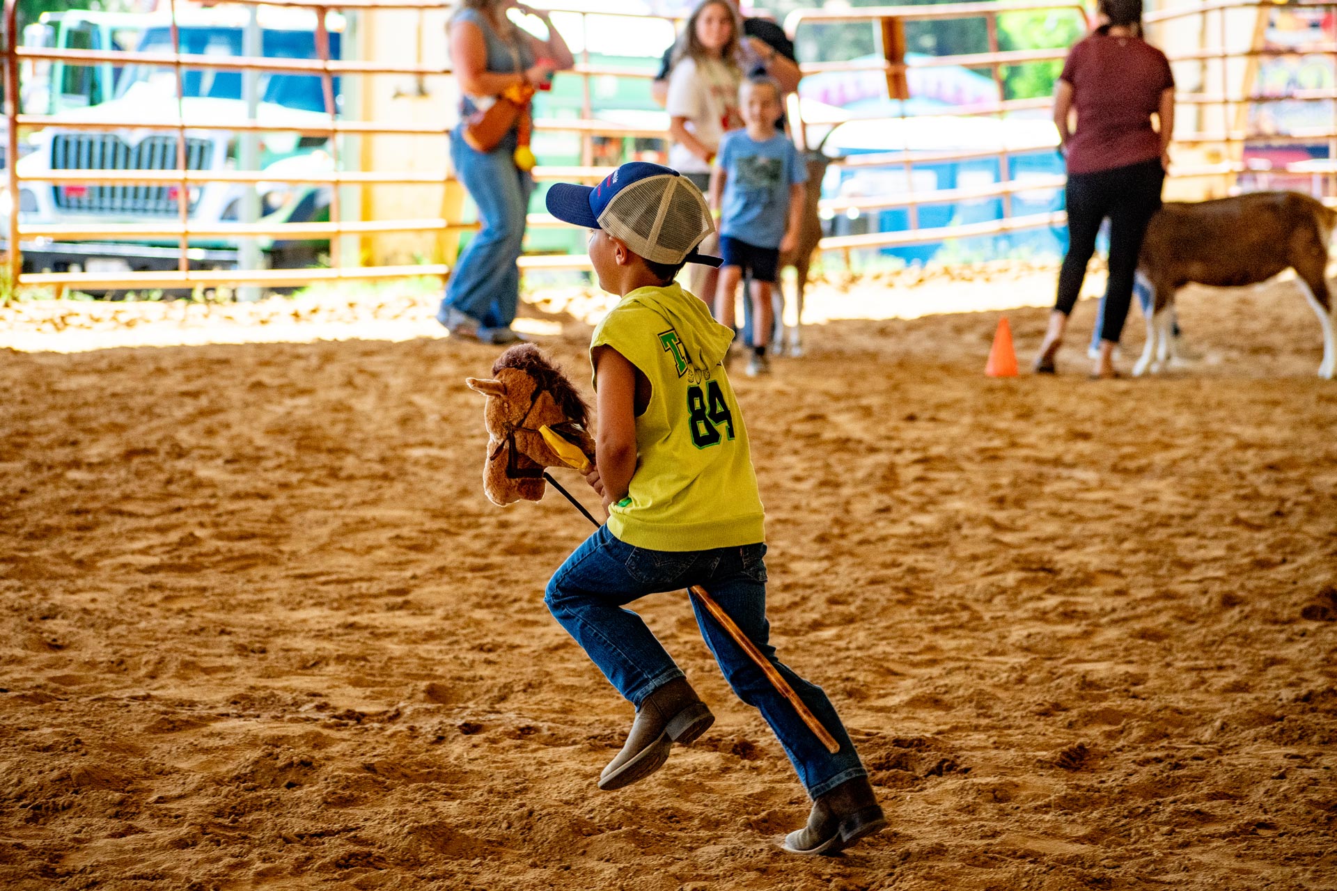 Pee Wee Rodeo Participant riding a stick horse.